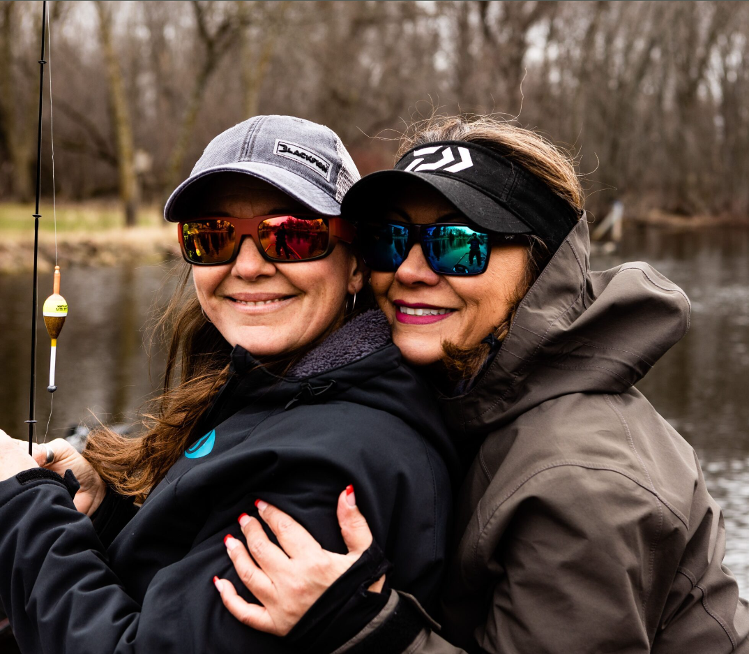 Two women fishing on a freshwater lake wearing RLVNT polarized fishing sunglasses