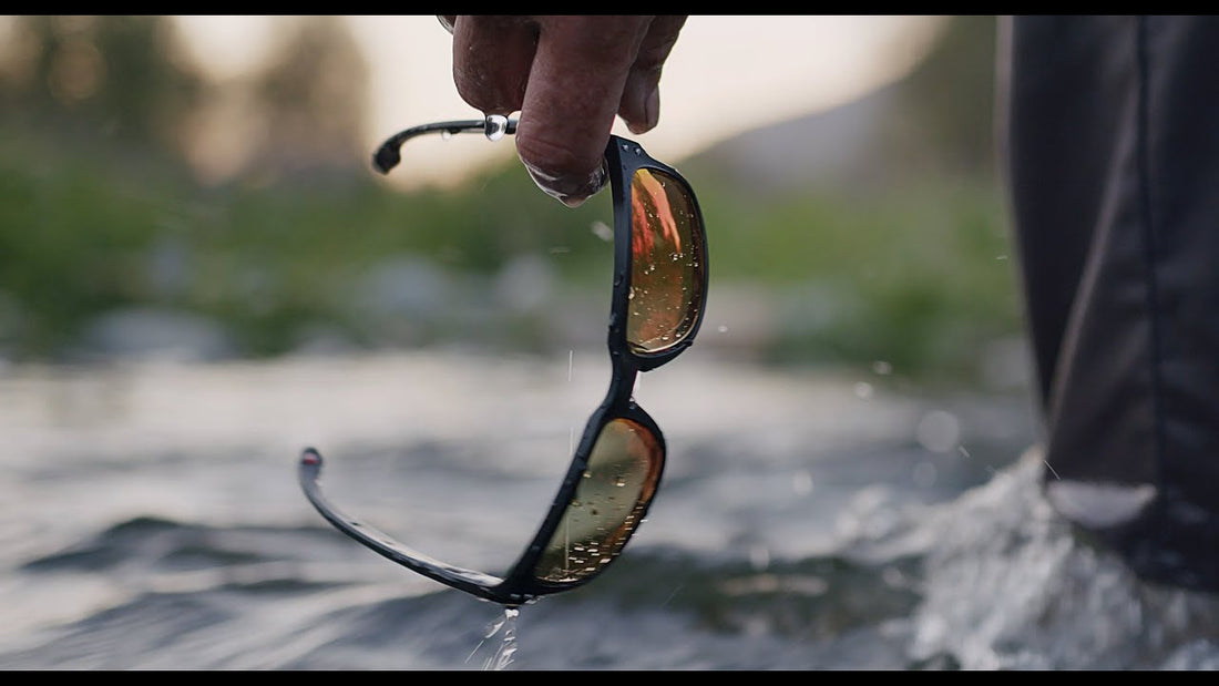 Angler holding polarized sunglasses in river