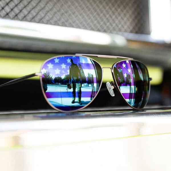 Sunglasses with reflective American flag design on a metallic surface
