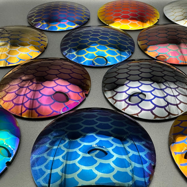 Lenses of various colors reflecting fish scale patterns.